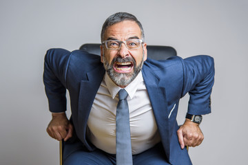 Enraged and furious business man yelling, screaming at you from his office chair