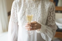 Mid-section Of Bride Holding A Glass Of Champagne