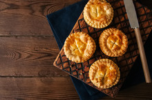 Mini Meat Pies From Flaky Dough On A Wooden Board Over Wooden Background.