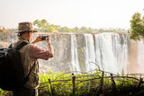 Photographer using smart phone at Victoria Falls