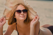 © olegphotor - Portrait of a smiling attractive  caucasian young woman in a glasses and hat on the beach
