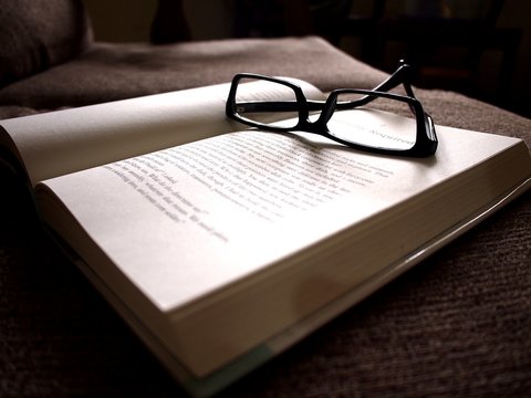 Book and eyeglasses on a couch