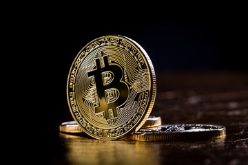 Bitcoin coins on gold and black colour background.