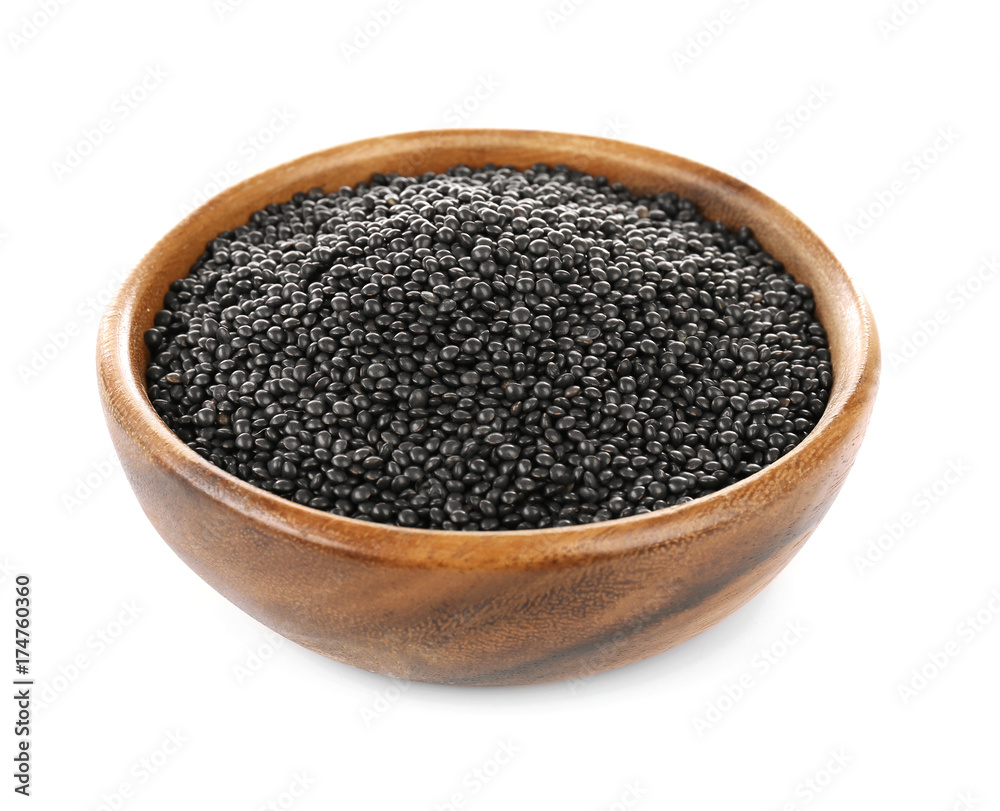 Wooden bowl with black lentils on white background