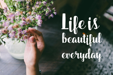 Life quote. Motivation quote on soft background. The hand touching purple flowers. Life is beautiful everyday.