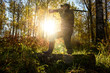 © river34 - A hunter with a gun in the forest at dawn.