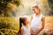 © svetabezu - Childhood, family, friendship and people concept - two happy kids sisters hugging outdoors.
