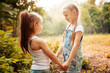 © svetabezu - Childhood, family, friendship and people concept - two happy kids sisters hugging outdoors.