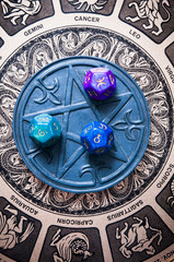 astrology dice with astrological symbols lying on a pentagram and zodiac background like esoteric co