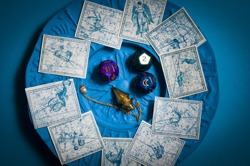 pendulum, dice with astrology symbols, zodiac signs over blue background