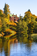 Country House On A Hill At A River In Autumn
