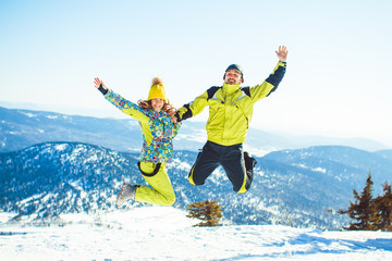 Couple jumping in the winter in the mountains