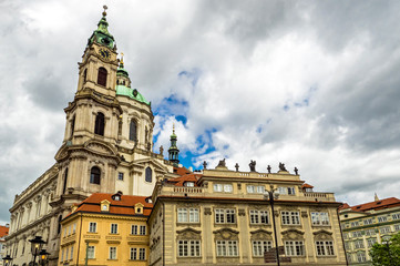 Wall Mural - Baroque church of St. Nicholas in Malá Strana quarter in the romantic Prague under blue sky. Panoramic of the old city of the hundred towers on a summer day in the capital of the Czech Republic. 