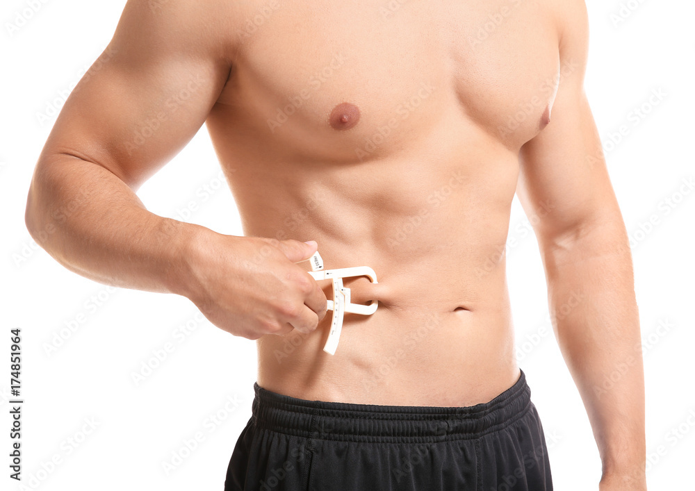 Sporty young man with measuring caliper on white background