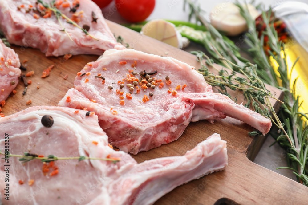 Wooden board with fresh raw meat, closeup