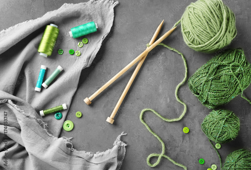 Composition with green sewing threads and knitting yarn on table