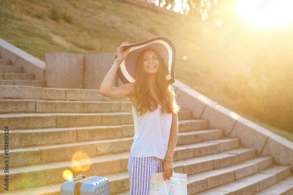 Beautiful young tourist with map outdoors