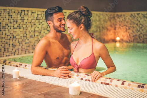 Plakat Szczęśliwa para relaksuje w ciepłym basenie przy hotelowym zdrojem