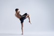 © Anatoliy Karlyuk - Full lenght shot of shirtless and barefooted young Caucasian male fighter raising one leg, ready to kick invisible enemy. Boxing, kickboxing, martial arts, sports, power and strenght concept