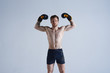 © Anatoliy Karlyuk - Serious confident European bearded male boxer wearing boxing gloves and black shorts raising hands in the air, feeling proud of himself after he won boxing championship. Determination concept