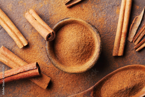 cinnamon-sticks-and-powder-on-brown-rustic-table-top-view-aromatic-spices