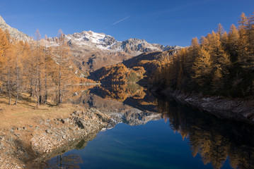 Scenics dam lake landscape with clear reflection on mountain in sunny autumn fall day outdoor.