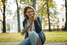 Beautiful Young Woman Feeding A Squirrel In An Autumn Park, A Squirrel Sitting On A Girl