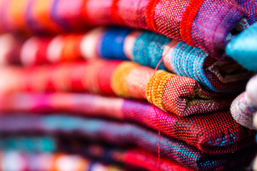 Colorful, vibrant red, blue, purple scarfs for sale on traditional medina souk