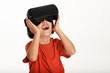 © javiindy - Little girl looking in VR glasses and gesturing with his hands.