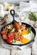 Traditional english breakfast. Pan with full english breakfast overhead rustic wooden table. Overhead view.