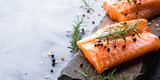 Fototapeta Tulipany - Raw salmon pieces on wooden board with herbs, salt and spices