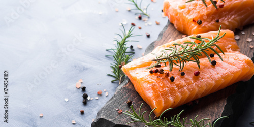 Cuadros en Lienzo Raw salmon pieces on wooden board with herbs, salt and spices