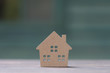© RobbinLee - miniature house  on wooden mock up over blurred green garden on day noon light.Image for property real estate investment concept.