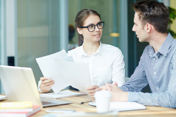 Canvas Print - Young economists with papers preparing for financial seminar and analyzing statistics