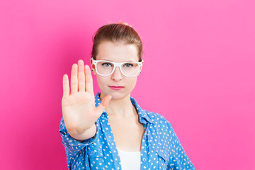 Wall Mural - Young woman making a rejection pose on a pink background