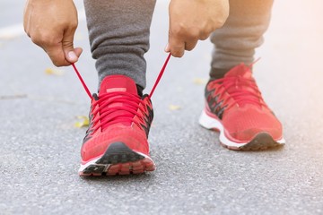 Wall Mural - Running shoes. Barefoot running shoes closeup. male athlete tying laces for jogging on road. Runner ties  getting ready for training. Sport lifestyle.