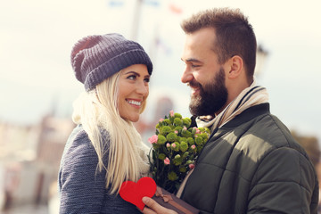 Wall Mural - Picture showing young couple with flowers dating in the city