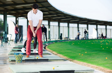 Wall Mural - Man playing golf is going to hit ball at golf course