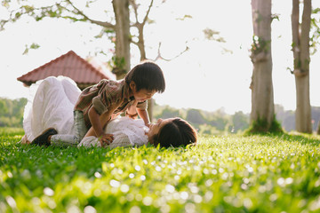 Wall Mural - child with mother playing at park,happy family concept.