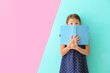© Africa Studio - Cute little girl with book on color background