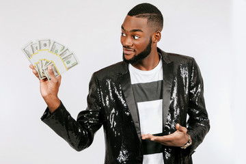 A black man with a bundle of money. The man is holding a bundle of dollars.