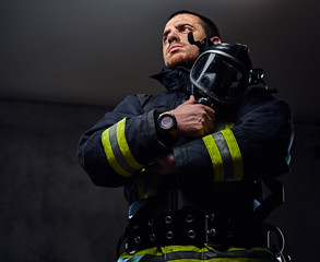 Studio portrait of a male dressed in a firefighter uniform.