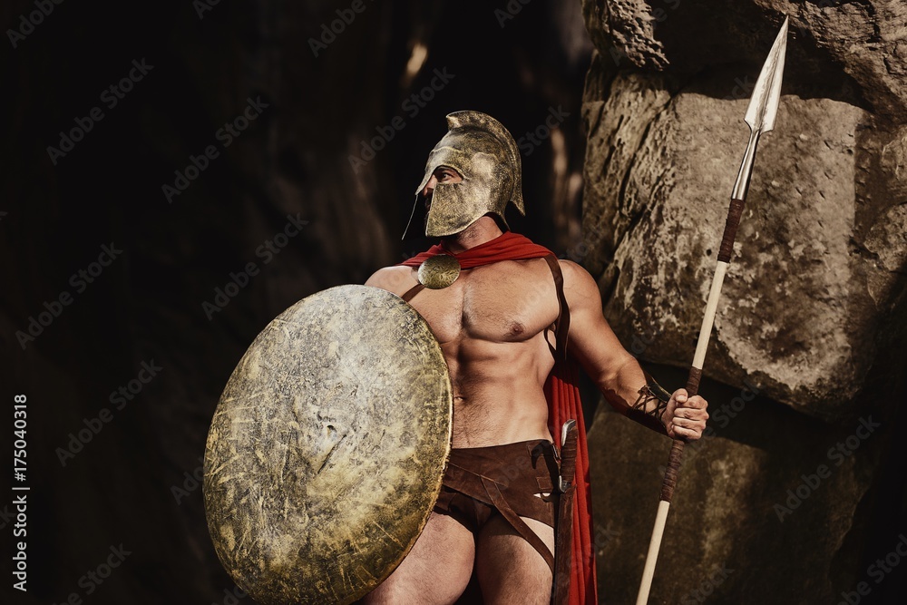 Muscular confident man in helmet and armor of ancient Roman warrior ...