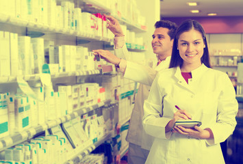 Wall Mural - Portrait of two friendly pharmacists working