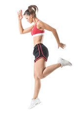 Wall Mural - Side view of sporty focused confident fitness woman jumping movement. Full body length portrait isolated on white studio background.