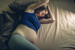 © Artem - Pregnant woman feeling pain in her belly lying in bed with insomnia at night. Concept of pregnancy and health