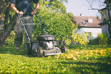 Mowing The Grass With A Lawn Mower In Early  Autumn 