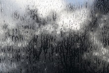 Wet Window In Autumn, Tree And Clouds In The Background