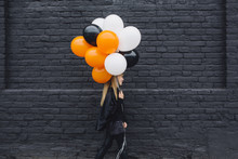 Blonde Girl In A Witch Halloween Costume Holding Balloons
