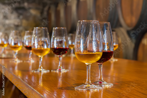 Fotografía glasses of red and white port wine with barrels in background, wine degustation